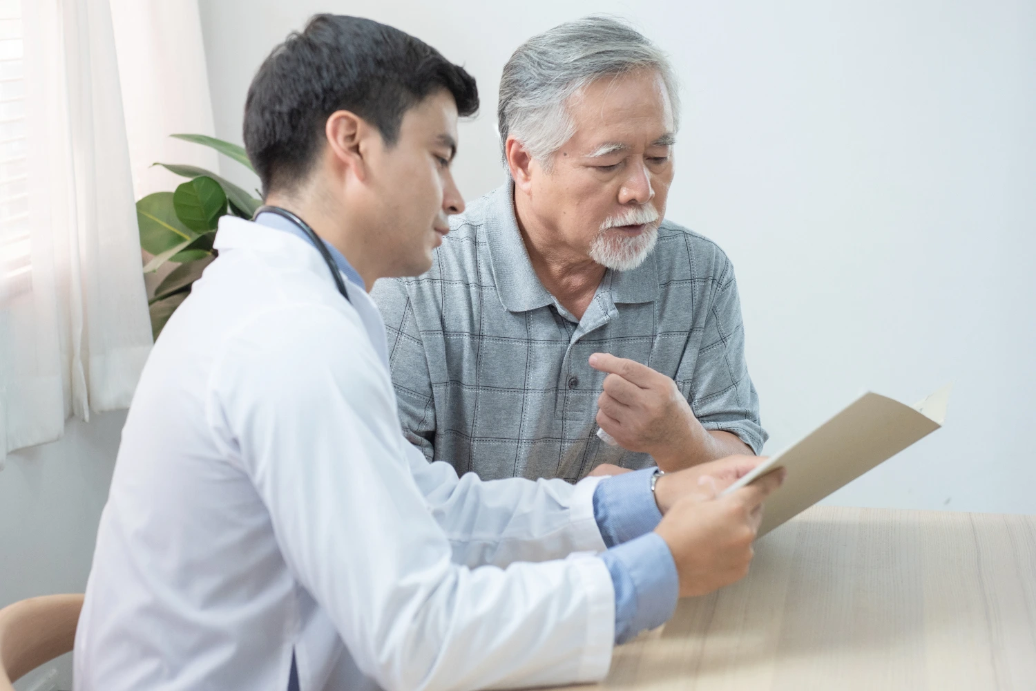 Elderly patient having chronic disease consultation session with Doctor at clinic.